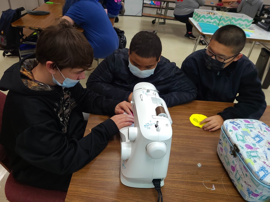 8th graders learning how to use the sewing machine and teaching each other to use it!