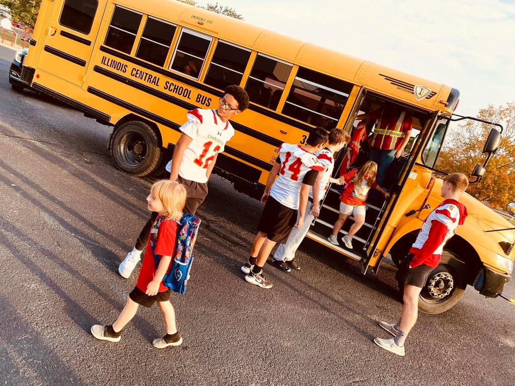 Football players greeting students getting off the bus