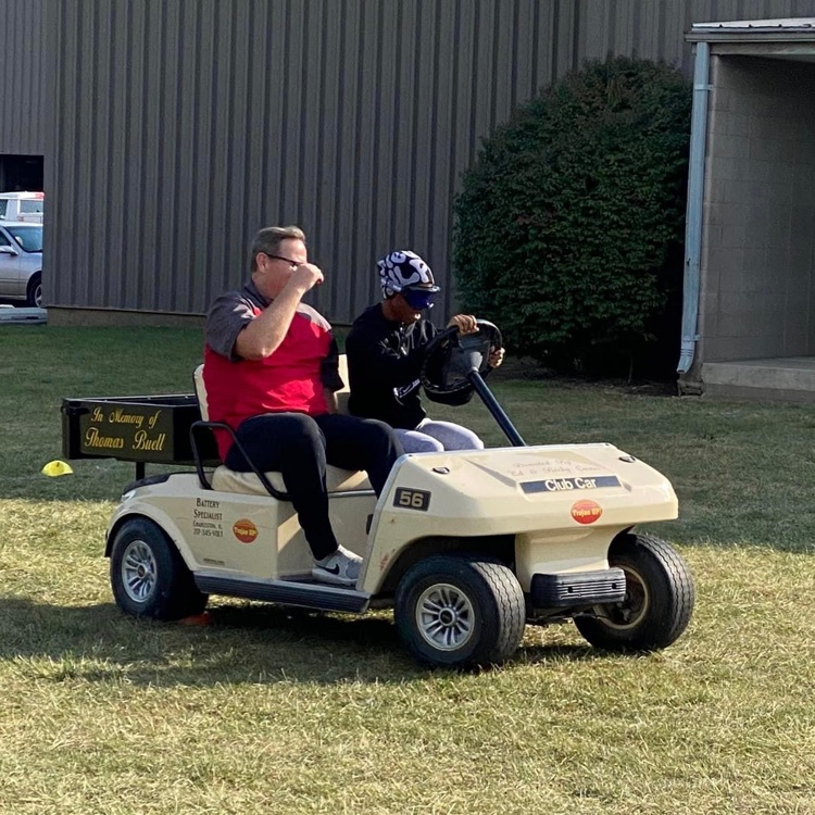 Drivers ed students driving a golf cart wearing drunk goggles
